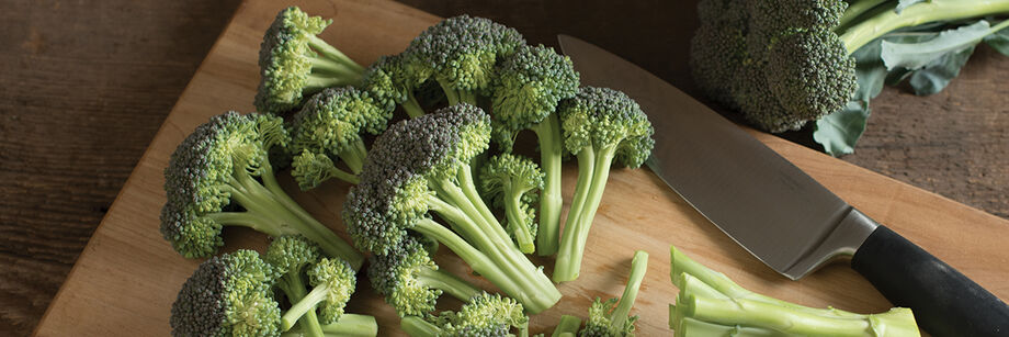 A head of broccoli from one of Johnny's broccoli varieties, shown sliced on a cutting board.